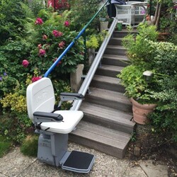 Der Lifta GTL 320 Außenlift an einer geraden Treppe, die vom Garten zur Terrasse führt