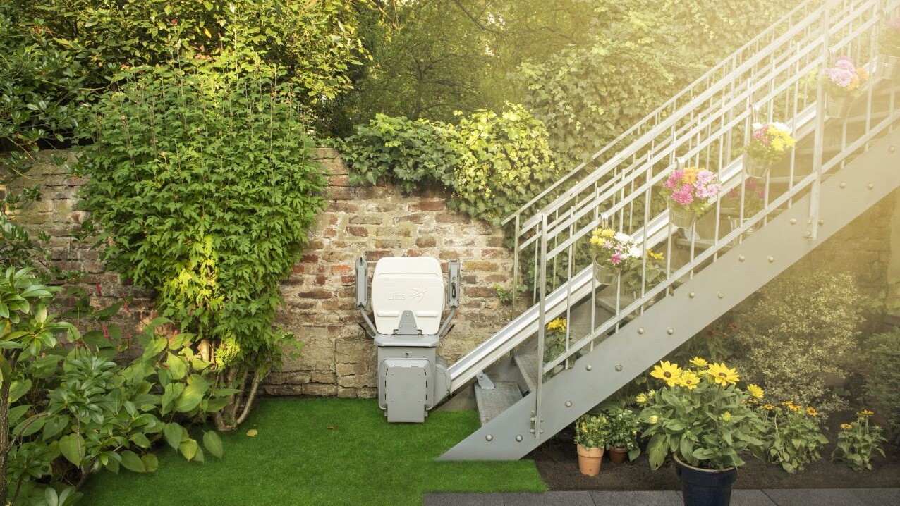 Der Lifta GTL 320 Außenlift in einem Privatgarten an einer geraden Metalltreppe