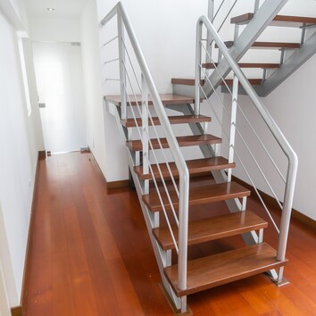 Sehr Schmale Podesttreppe mit Metallgeländer in einem kleinen Flur