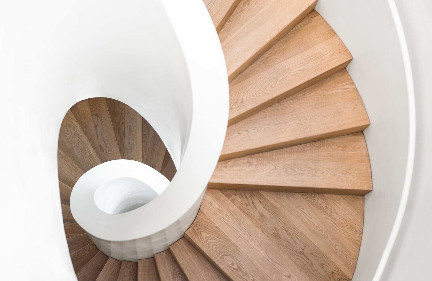 97282778 | ©Martin Vlček - stock.adobe.com Hell Wendeltreppe mit Holzstufen von oben