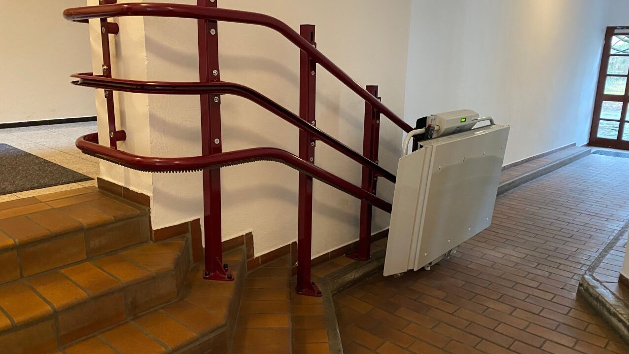 Der klappbare Rollstuhllift Flexa an einem kleinen Treppenaufgang