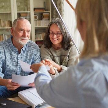 549671945 | © Robert Kneschke - stock.adobe.com Zwei Senioren halten Dokumente in den Händen und werden von einer dritten Person beraten