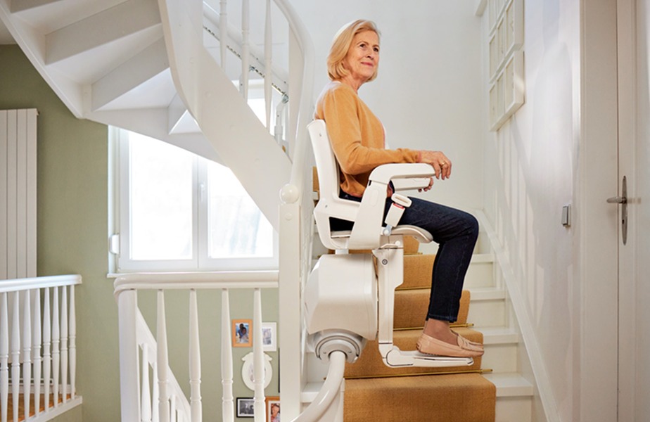 Eine Dame sitzt angeschnallt auf einem Sitzlift